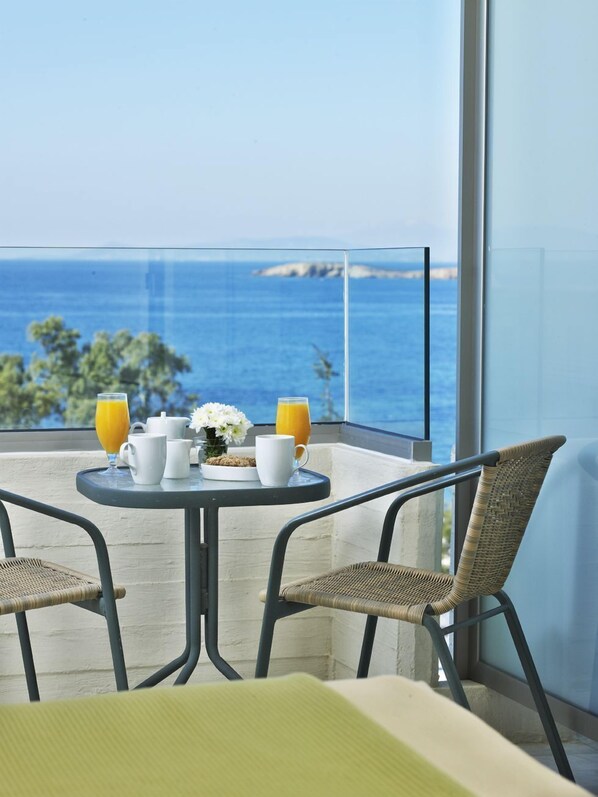 A balcony with a table set for breakfast, overlooking the sea. - Amarilia Hotel (Vari-Voula-Vouliagmeni)