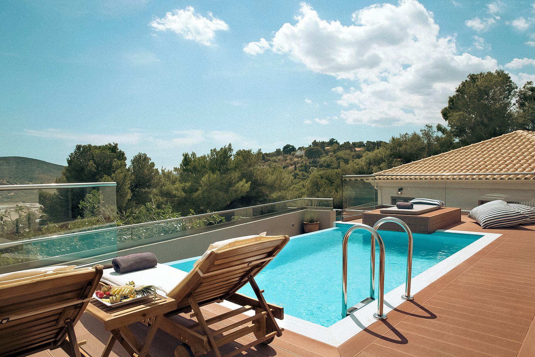 A rooftop pool area with lounge chairs and a clear view of the surrounding landscape.