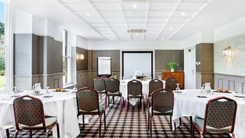 A conference room with a checkered floor, white tables, and patterned chairs.