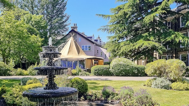 A garden with a fountain, manicured lawns, and a house in the background. - Cedar Court Harrogate (Harrogate)