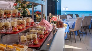 Een buffet met diverse desserts en uitzicht op de oceaan.