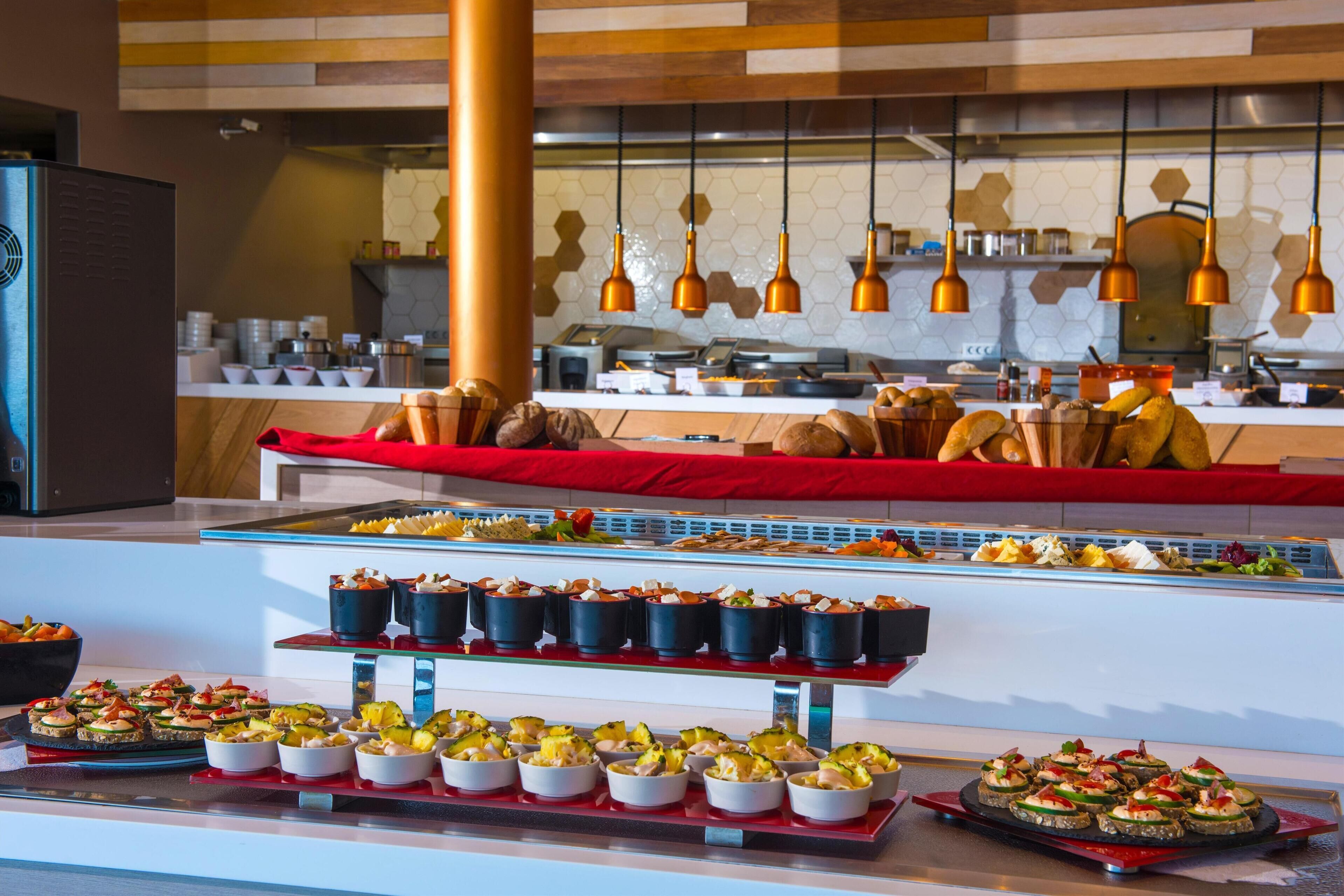 Ein Buffet mit verschiedenen Speisen und eine Küchenzeile im Hintergrund.