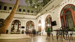 A courtyard with arched windows, a fountain, and outdoor seating. - Londonskaya Hotel (Odesa)