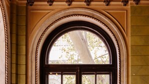 An arched doorway with a window, leading to a building with visible architectural details. - Londonskaya Hotel (Odesa)