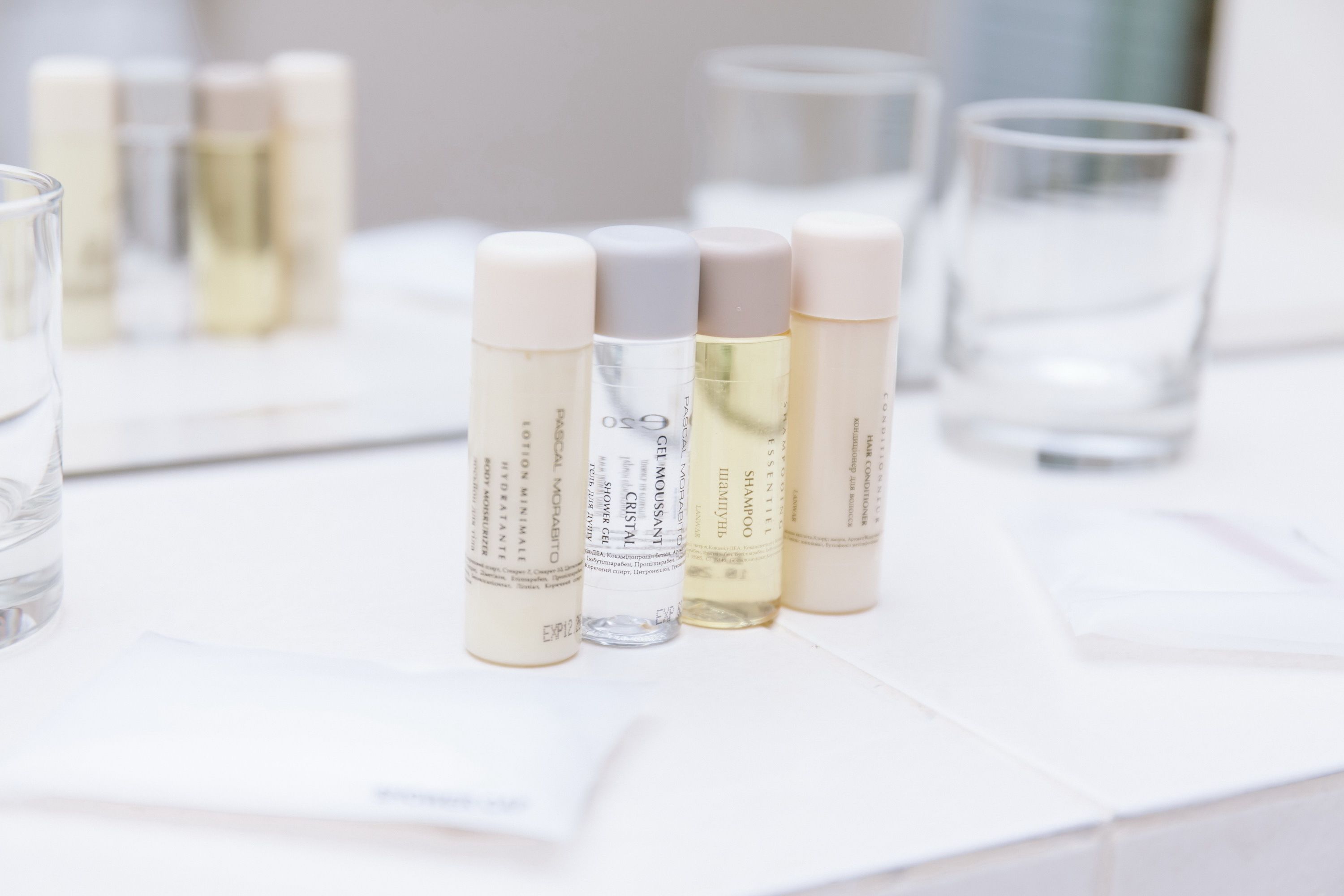 Varias botellas de productos para el cuidado de la piel sobre una superficie blanca.