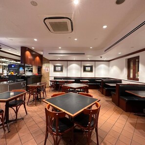 A restaurant interior with booths and tables, a bar area, and tiled flooring. - Park View Hotel Singapore (Singapore)