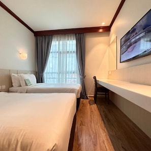 A hotel room with two beds, a desk, a chair, a large window with curtains, and a mounted TV. - Park View Hotel Singapore (Singapore)