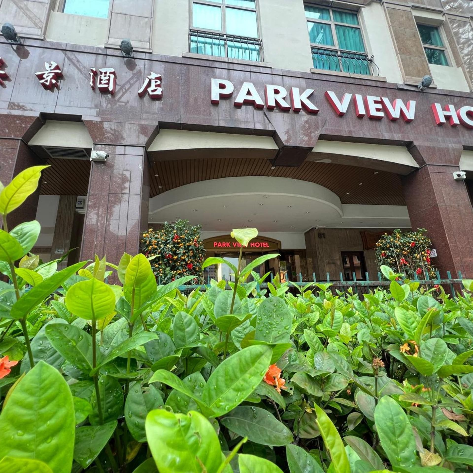 Entrada de un hotel con un letrero que dice 'PARK VIEW HOTEL' y una puerta de acceso visible.