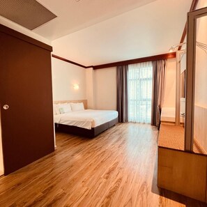 A hotel room with a bed, a wooden floor, a window with curtains, and a door. - Park View Hotel Singapore (Singapore)