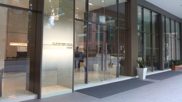 A modern hotel entrance with large glass doors, a reception desk, and a sign reading "Summerview Hotel". - Summer View Hotel (Singapore)