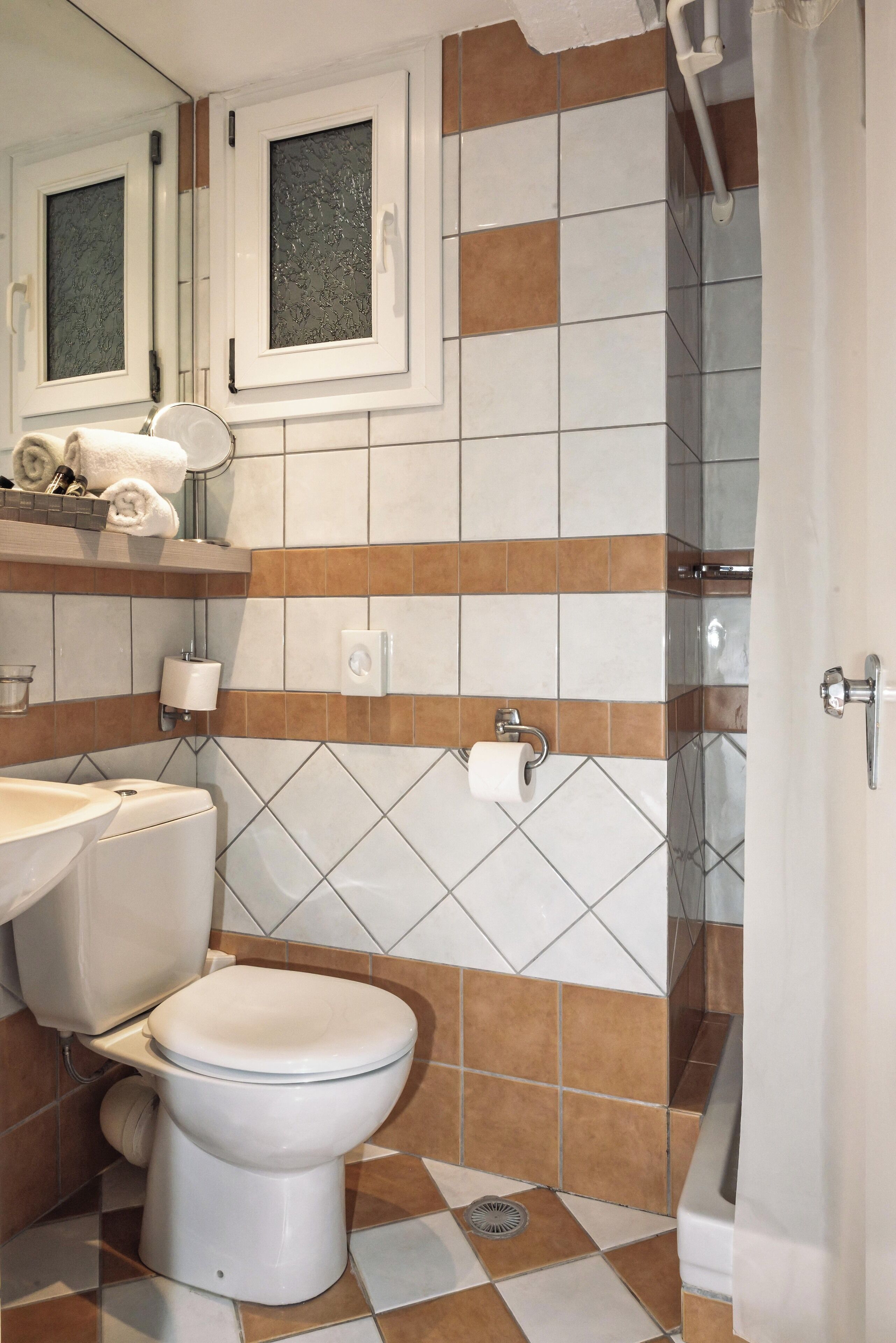 Ein Badezimmer mit Toilette, Waschbecken und Duschbereich.