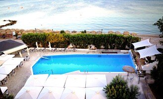 Una piscina al aire libre de temporada, sombrillas