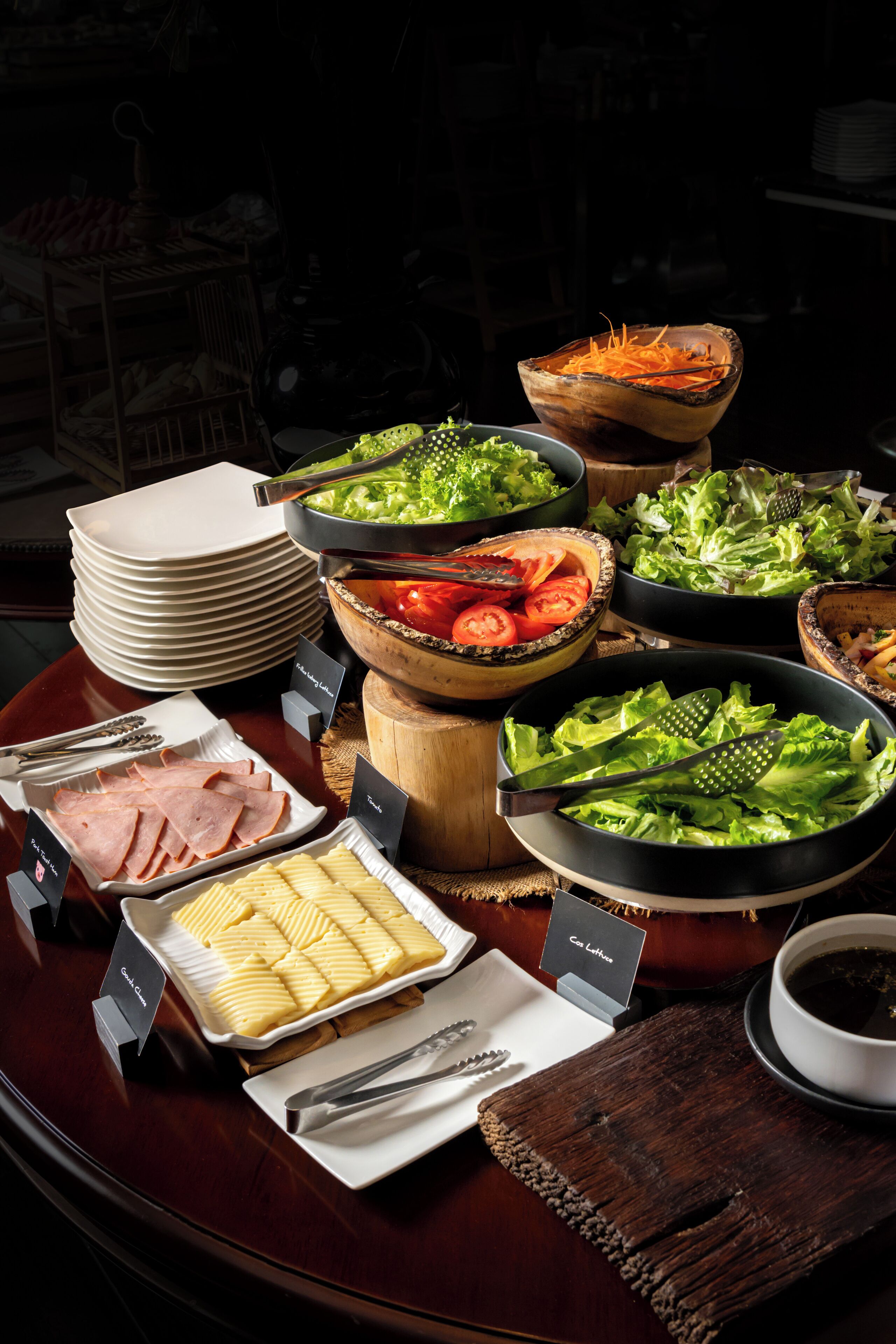 A buffet table with various food items and utensils.