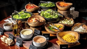 Una mesa de bufé con diversos alimentos y salsas.