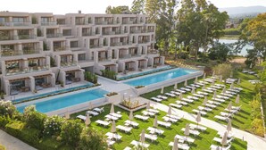 Un hôtel moderne doté de nombreux balcons, d’une piscine centrale et d’espaces de détente en plein air.