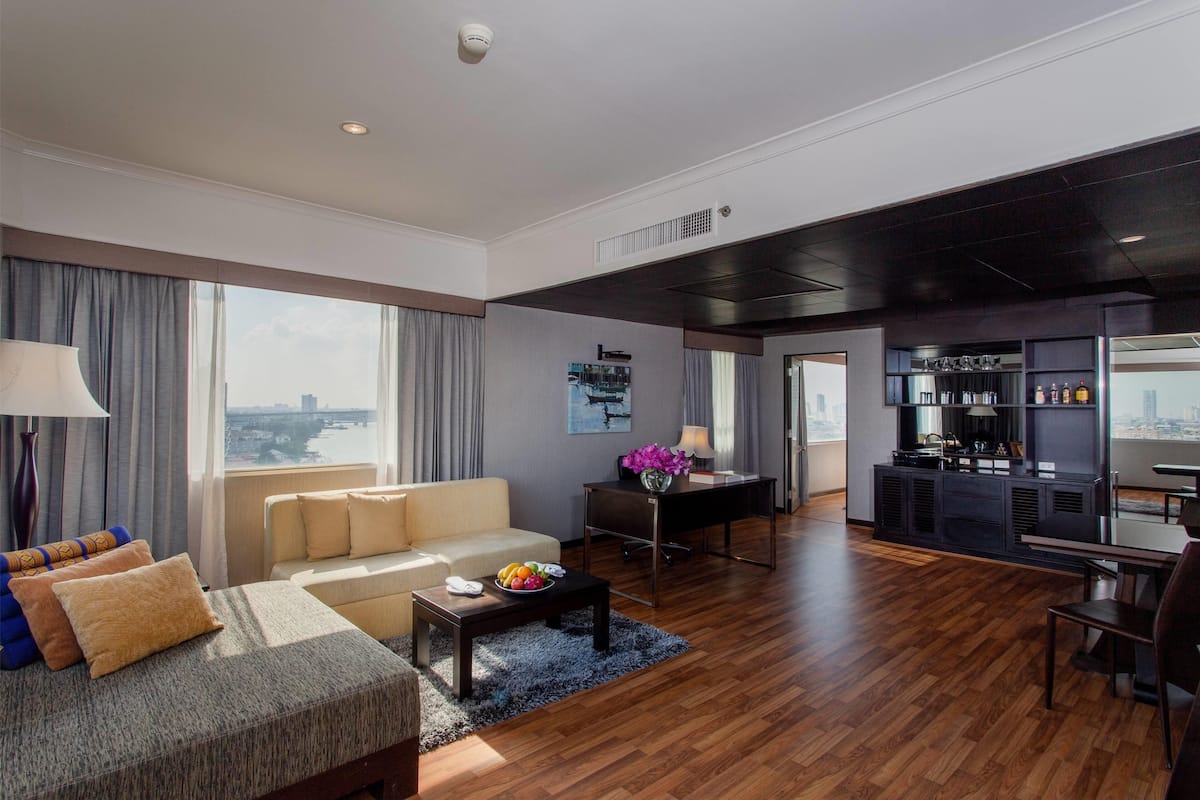 A spacious living area with a sofa, coffee table, and a view of the city.