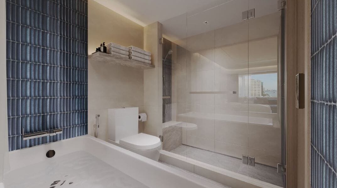 A modern bathroom with a glass shower enclosure, a standalone toilet, and a large bathtub.