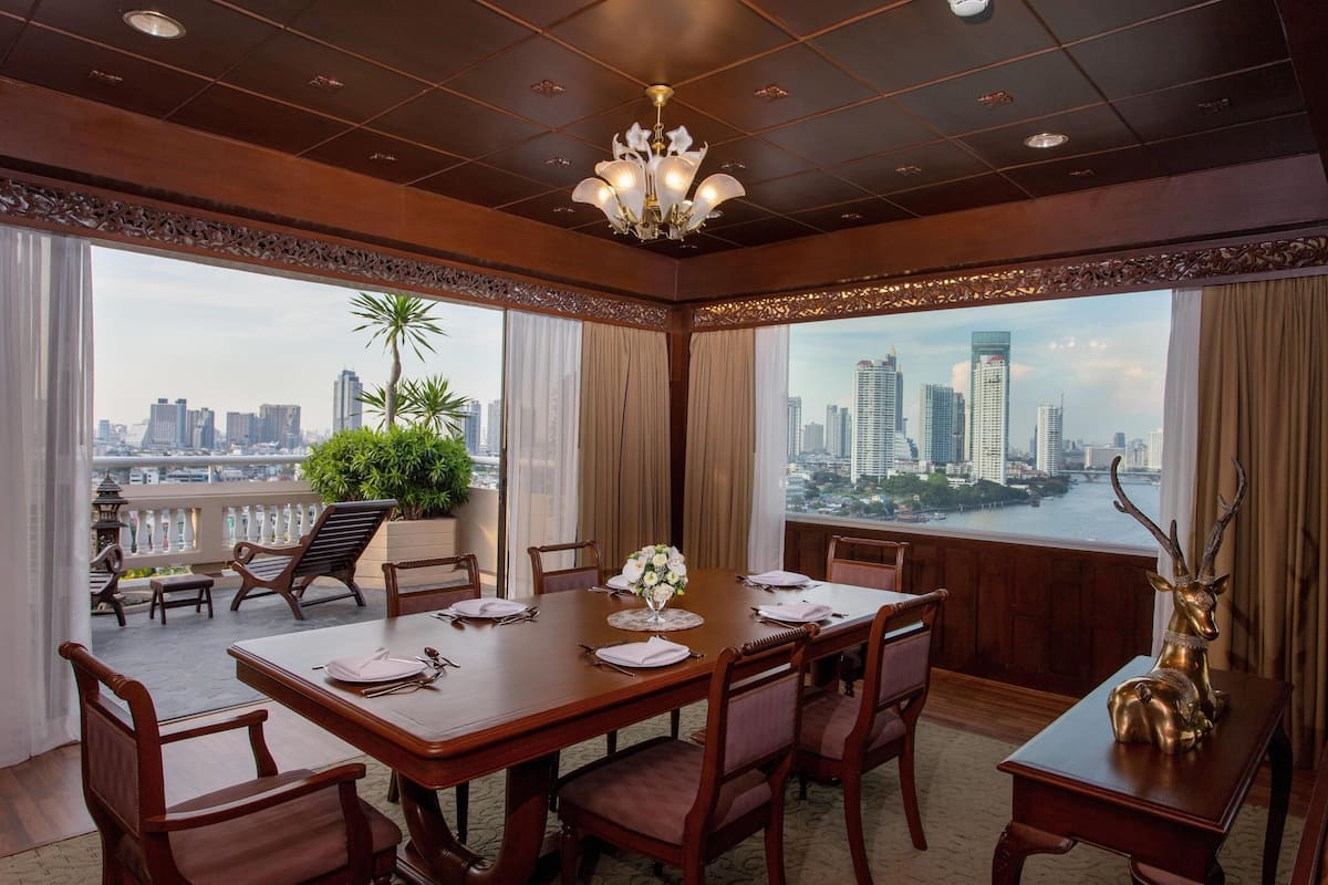 A conference room with a city view, a chandelier, and a table set for a meeting.