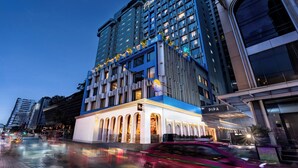 A multi-story hotel with a prominent 'PIPA' sign, large windows, and a well-lit entrance. - Pipa Bangkok Sukhumvit 11 by Kingston Hotels (Bangkok)
