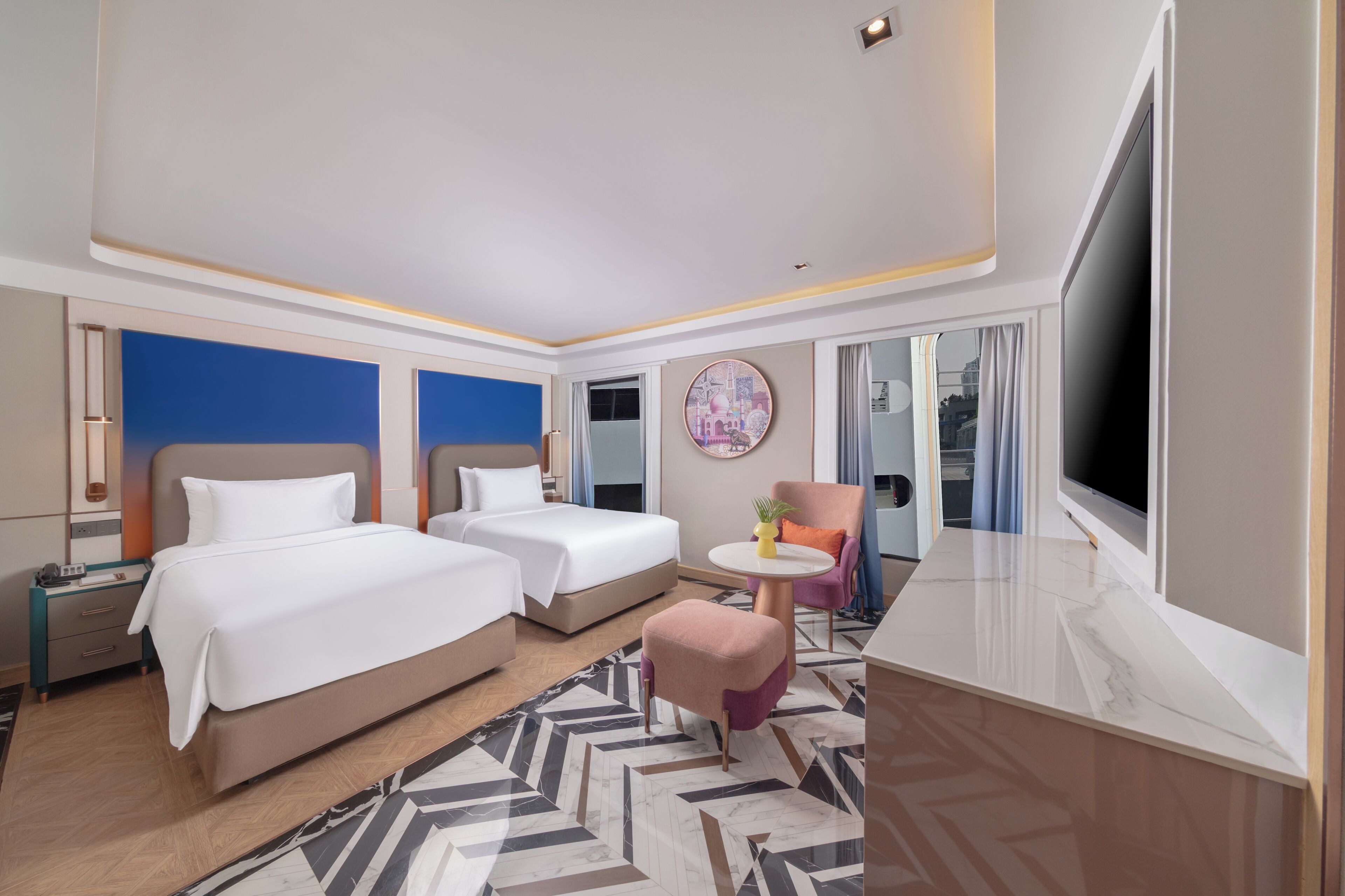 Ett hotellrum med två sängar, ett litet runt bord, en stol, en tv och ett stort fönster.
