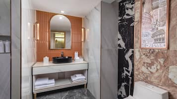 Une salle de bain moderne avec un meuble-lavabo en marbre, un grand miroir et un tableau encadré au mur.