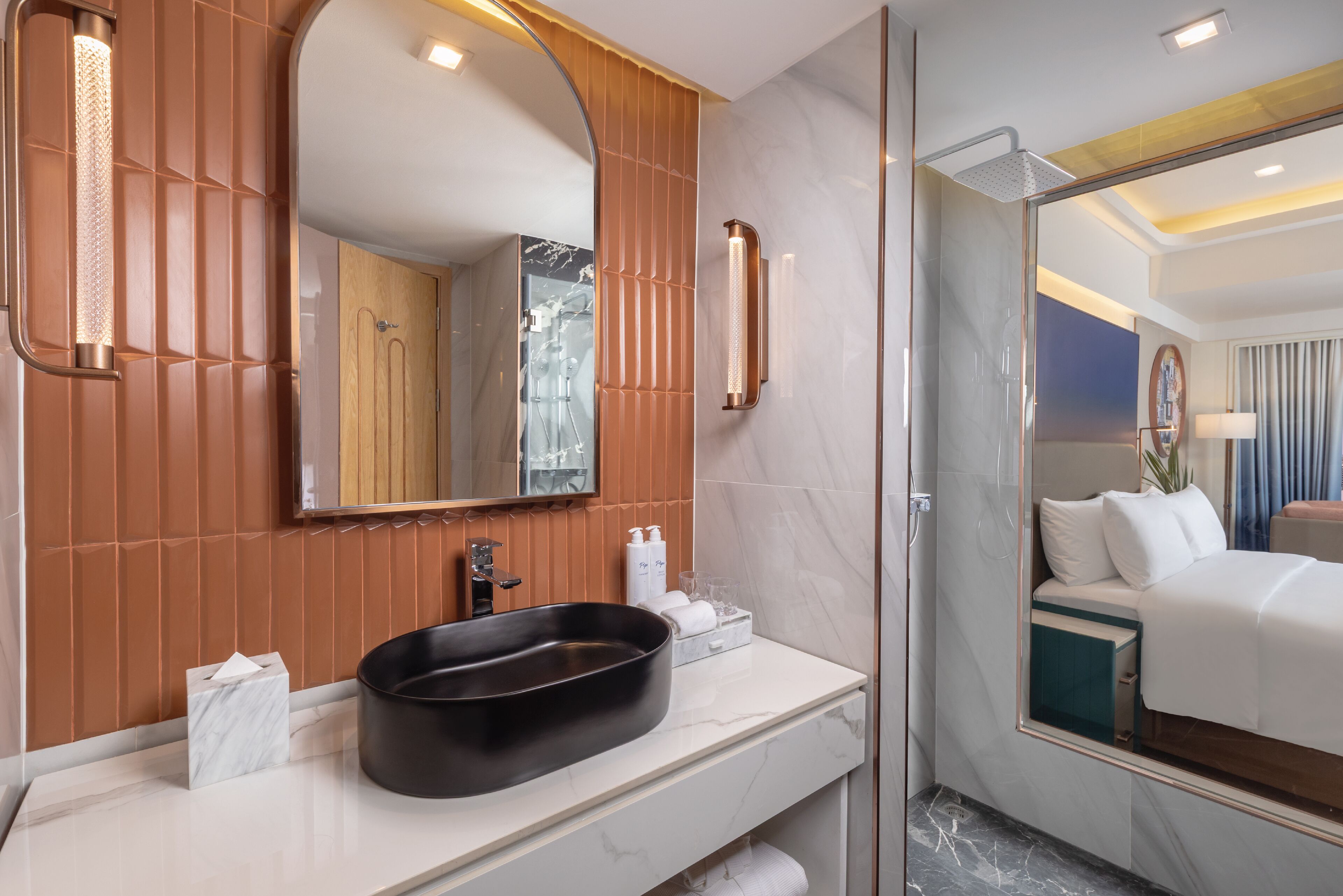 A modern bathroom with a marble vanity, a large mirror, and a glass-enclosed shower.