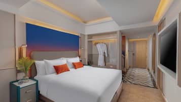 Een moderne hotelkamer met een groot bed, een inloopkast en een televisie.