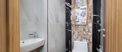 Un baño con lavamanos blanco, inodoro y ducha.