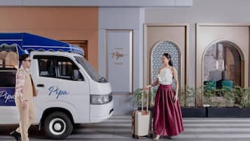 A white van with 'Pipa Hotel' branding parked in front of a building with a sign that reads 'Pipa Hotel.'