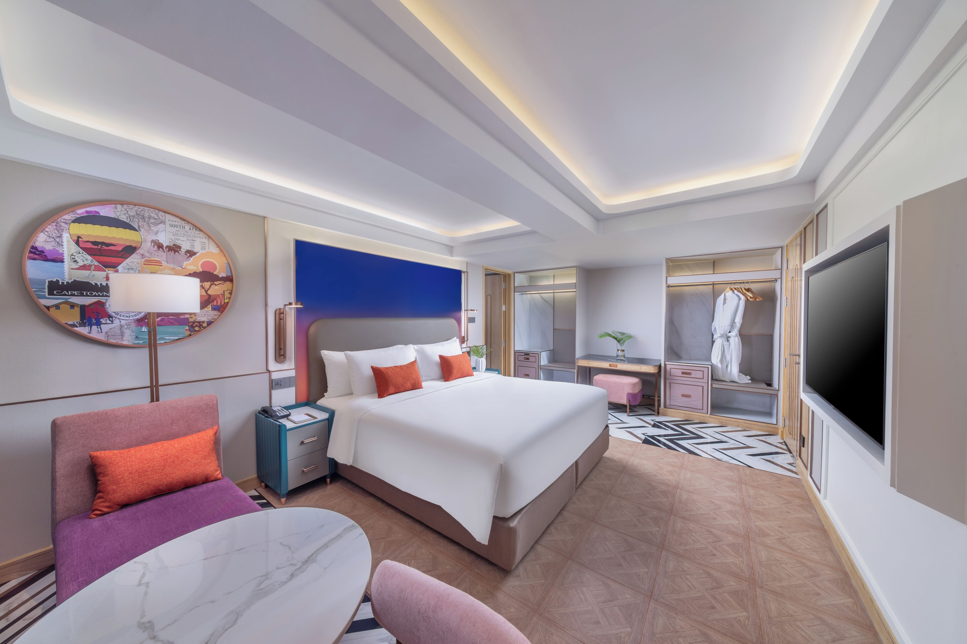 Una habitación de hotel moderna con una cama grande, un televisor, un escritorio y un vestidor.