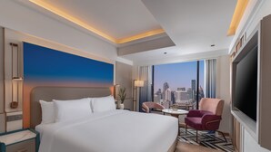 A hotel room with a large bed, a desk, a chair, a TV, and a city view. - Pipa Bangkok Sukhumvit 11 by Kingston Hotels (Bangkok)