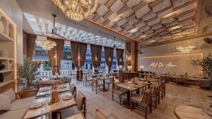 A restaurant with wooden tables, chairs, and a ceiling with a unique fabric design. - Pipa Bangkok Sukhumvit 11 by Kingston Hotels (Bangkok)