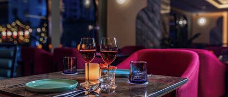 A dining table with three wine glasses, a candle, and a plate.