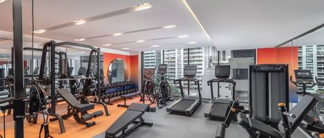 Ein Fitnessstudio mit verschiedenen Trainingsgeräten, darunter Laufbändern und Kraftgeräten.