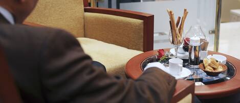 A dining table with a tray of food, a candle, and a coffee pot.