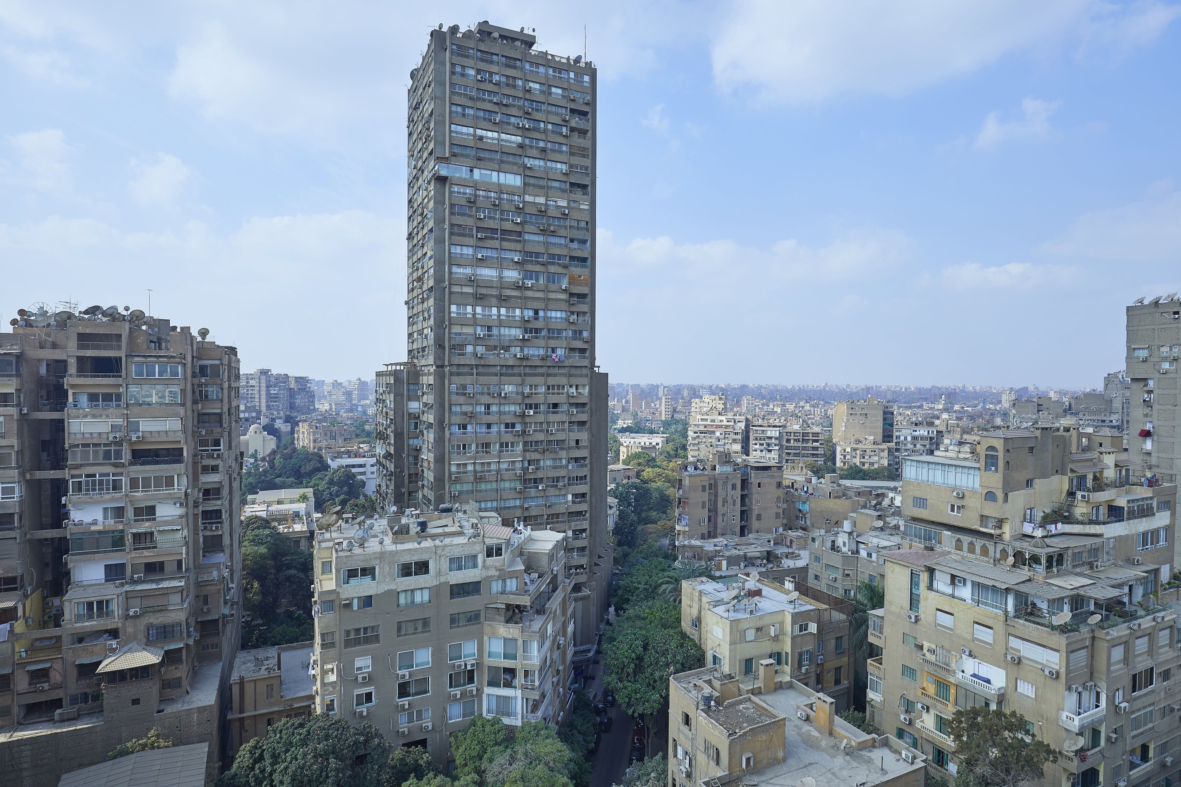 A high-rise building with multiple floors, surrounded by other residential buildings.