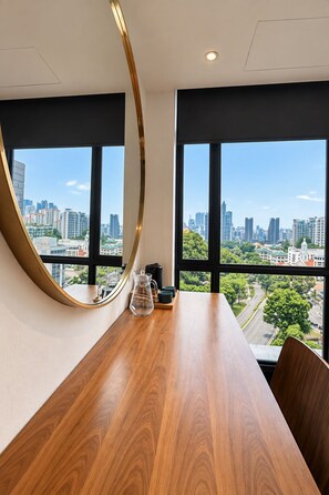 A conference room with a wooden table, a glass pitcher, and two cups. It features large windows with a cityscape view. - YWCA Fort Canning (Singapore)