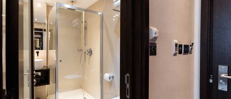 A modern bathroom with a glass-enclosed shower, a toilet, and a sink.