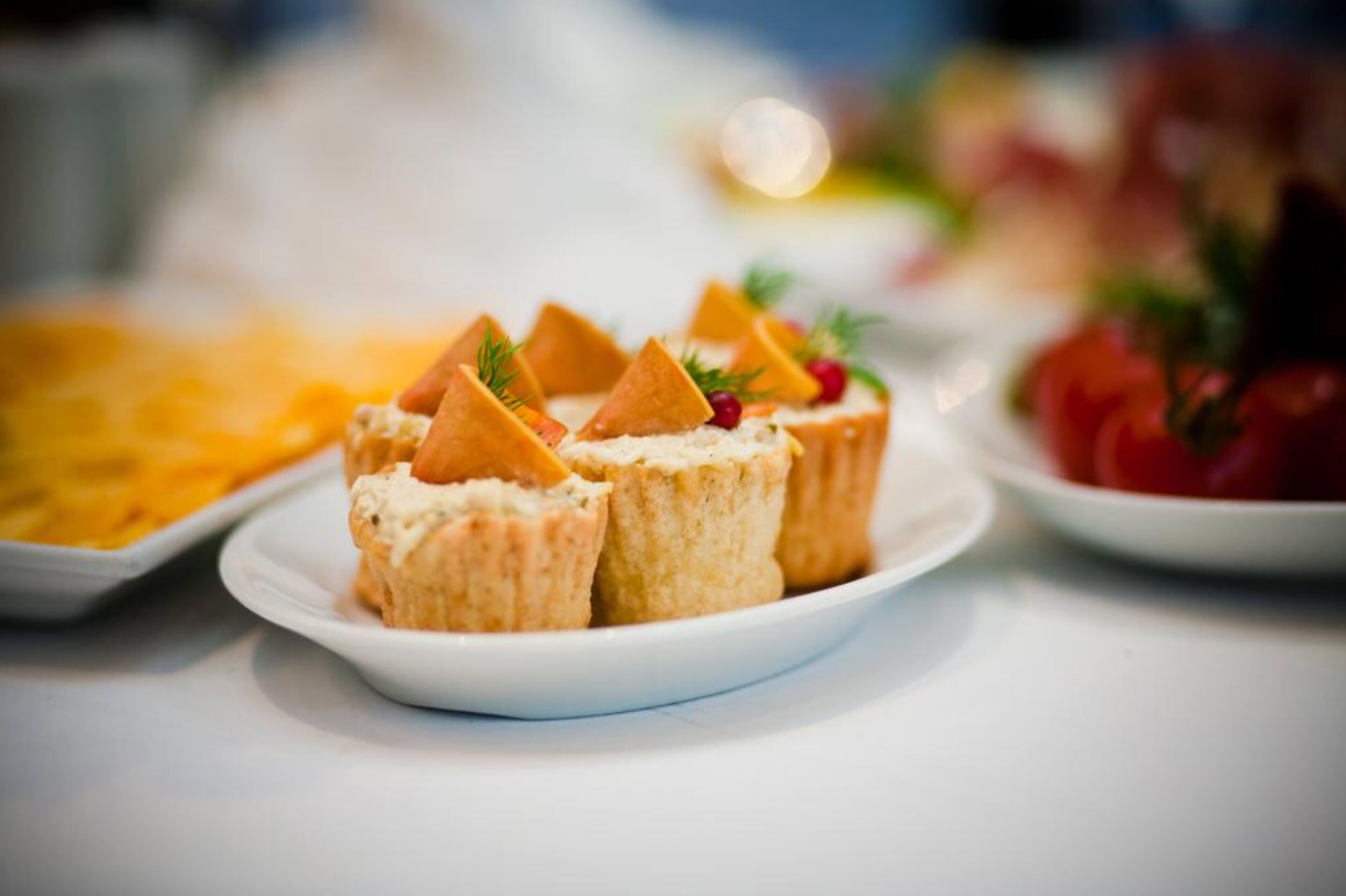 A plate of food with triangular-shaped items and garnishes, possibly a dessert or appetizer, on a white plate.