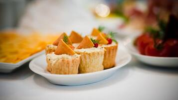 A plate of food with triangular-shaped items and garnishes, possibly a dessert or appetizer, on a white plate.