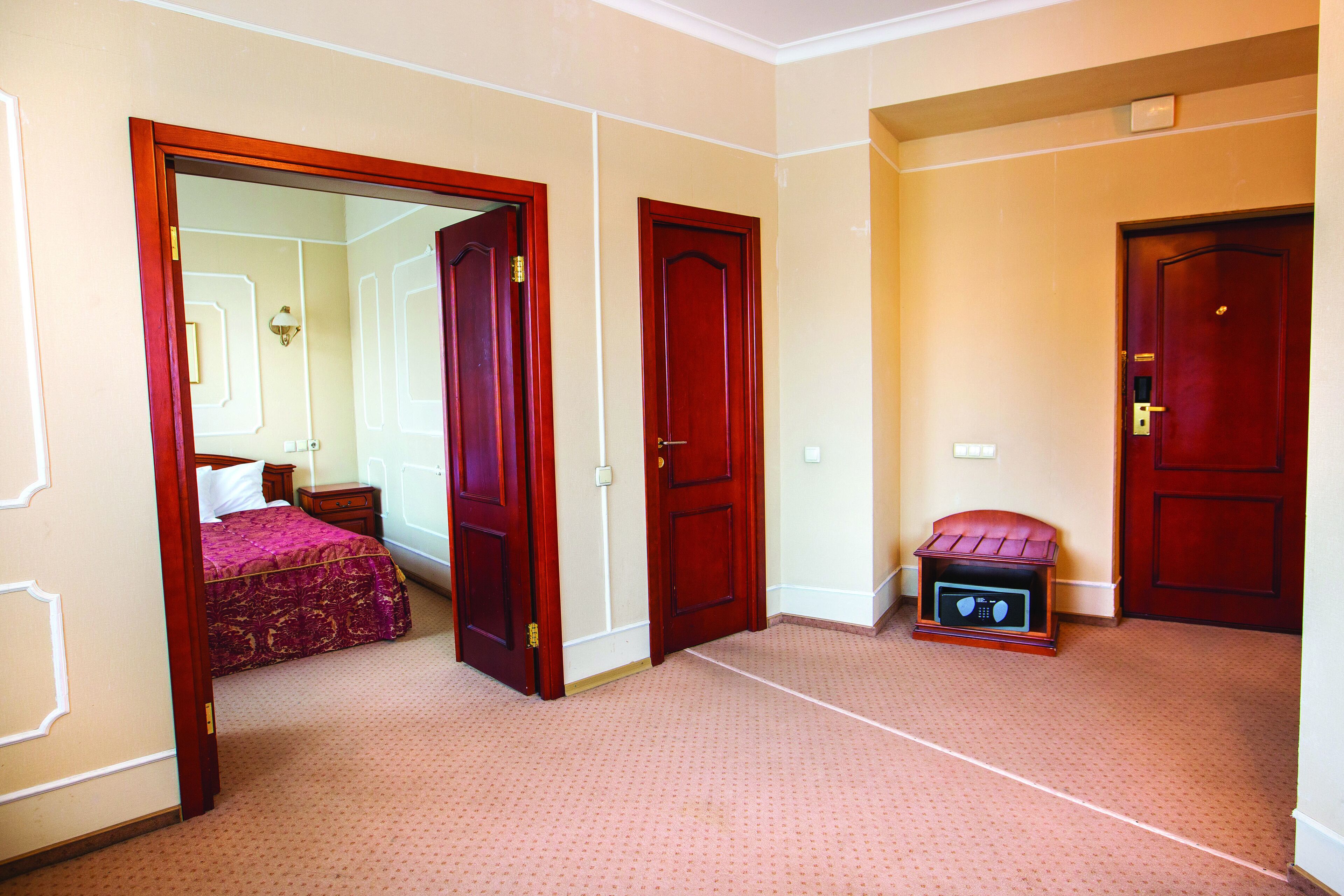 Une chambre d’hôtel avec un lit, une table de chevet, une petite table et un four à micro-ondes.