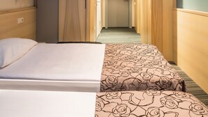 A hotel room with a bed, a bedside table, a lamp, and a view of the hallway. - Ibis Styles Riga (Riga)