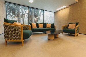 A modern interior with a sectional sofa, two armchairs, and a coffee table. - Mimi Hotel Chisinau (Chisinau)
