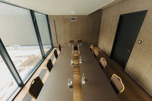A conference room with a long table, chairs, and a door. - Mimi Hotel Chisinau (Chisinau)