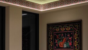 A modern living room with a sofa, armchair, and coffee table, a patterned rug, and a large framed artwork on the wall. - Mimi Hotel Chisinau (Chisinau)
