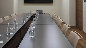 A conference room with a long table, chairs, a flat-screen TV, and ceiling lights. - Mimi Hotel Chisinau (Chisinau)
