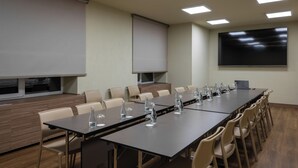 A conference room with a long table, chairs, a projector screen, and a television. - Mimi Hotel Chisinau (Chisinau)