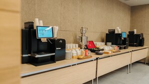 A long counter with coffee machines, a trophy, and various cups and plates. - Mimi Hotel Chisinau (Chisinau)