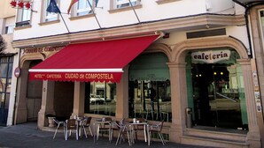 Een hotel met meerdere verdiepingen, een rode luifel en vlaggen.