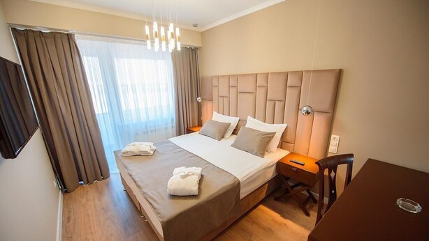 Ein Hotelzimmer mit einem großen Bett, einem Schreibtisch und einem Stuhl.